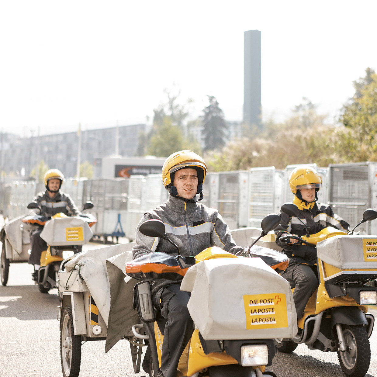 Post-Mitarbeitende auf Motorfahrrädern liefern Post aus